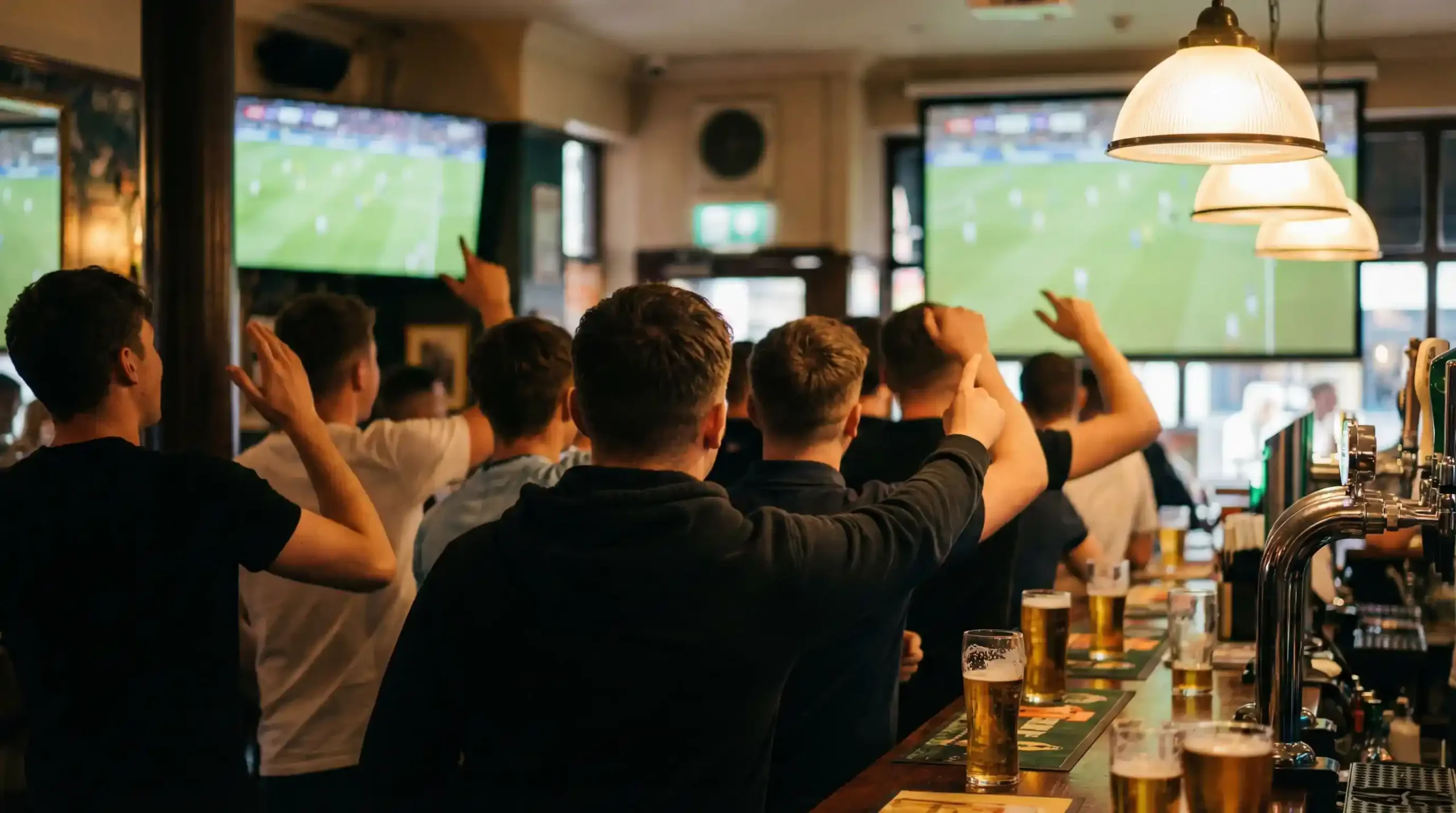 Groupe de supporters de football dans un bar regardant un match à la télévision